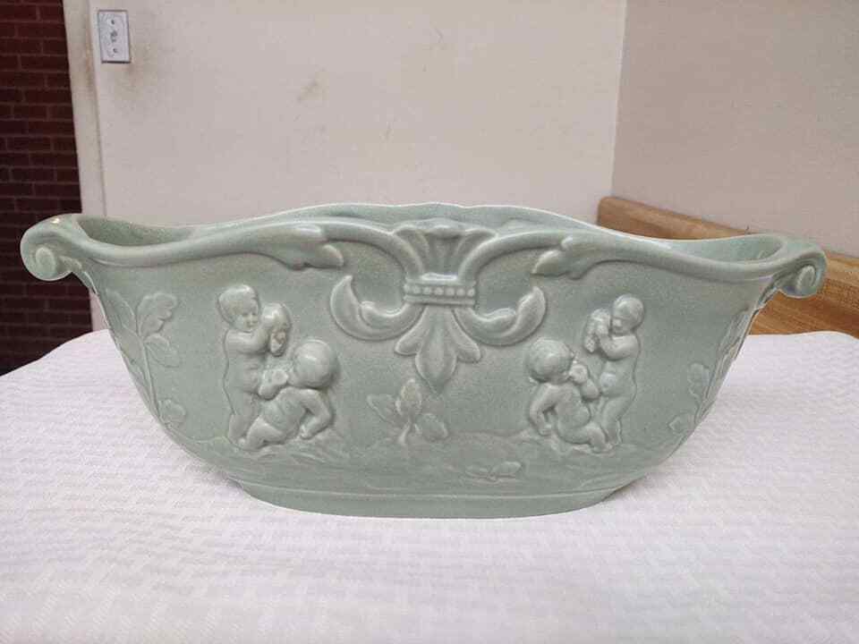 Vintage Rumrill pottery bowl with raised design cherubs and foliage.