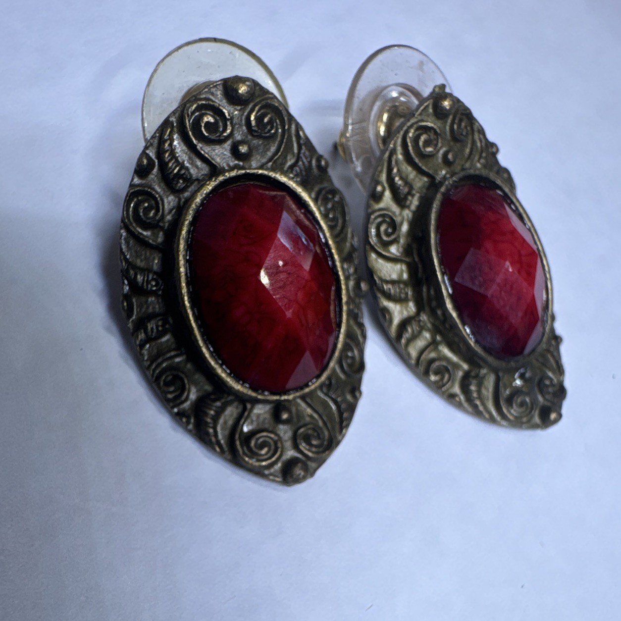 vintage statement earrings feature deep red oval center stones framed by bronze