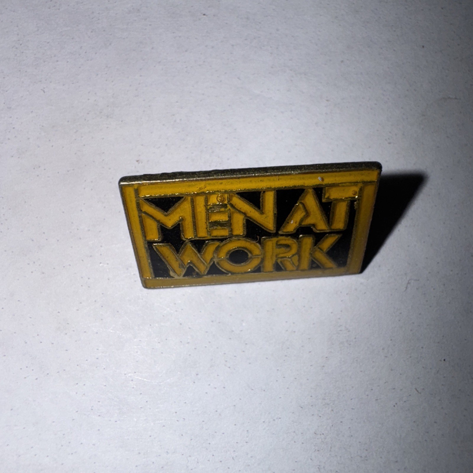 Men at Work vintage enamel Rock lapel or hat pin. Men at Work vintage enamel Rock lapel or hat pin.