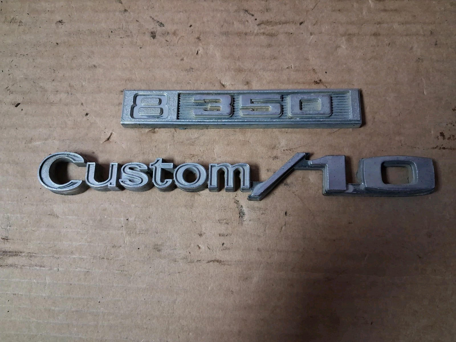These original factory badges belong to a 1969–1972 Chevrolet C10 pickup truck
