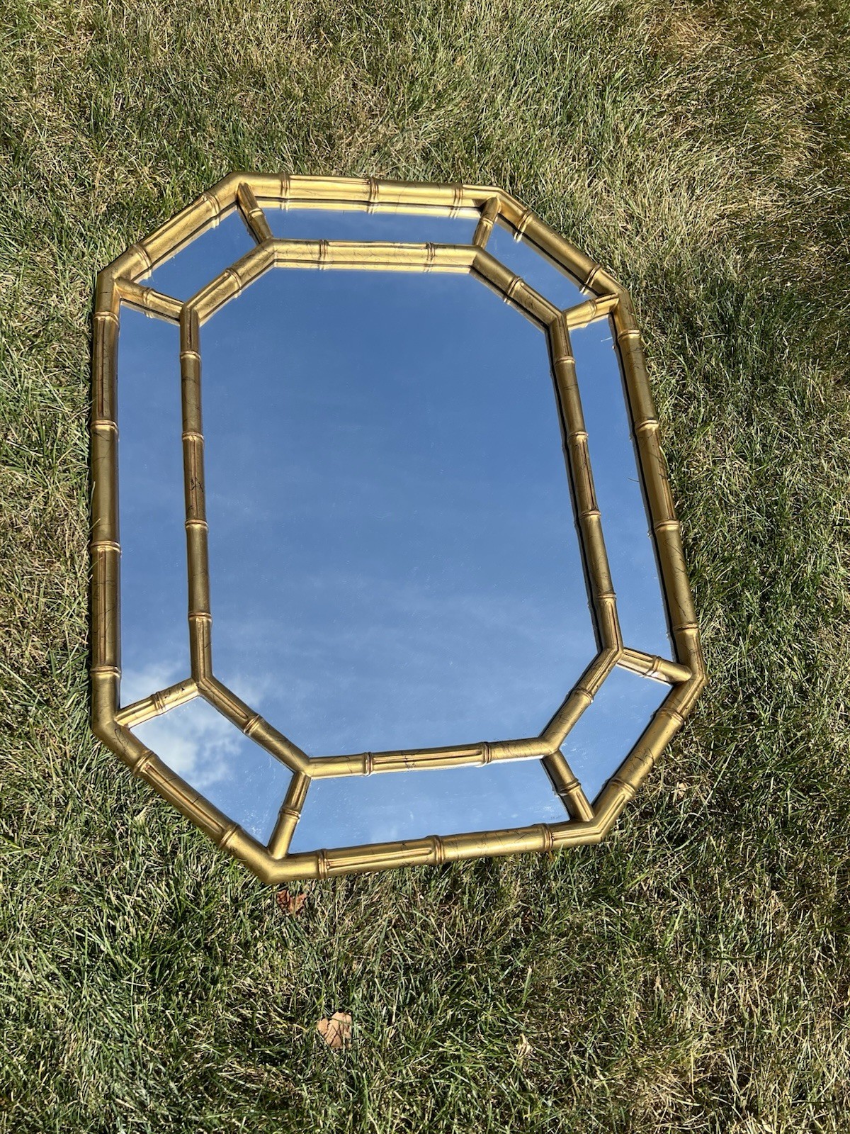 Vintage gold faux bamboo octagonal wall mirror with a double-frame design. Vintage gold faux bamboo octagonal wall mirror with a double-frame design.