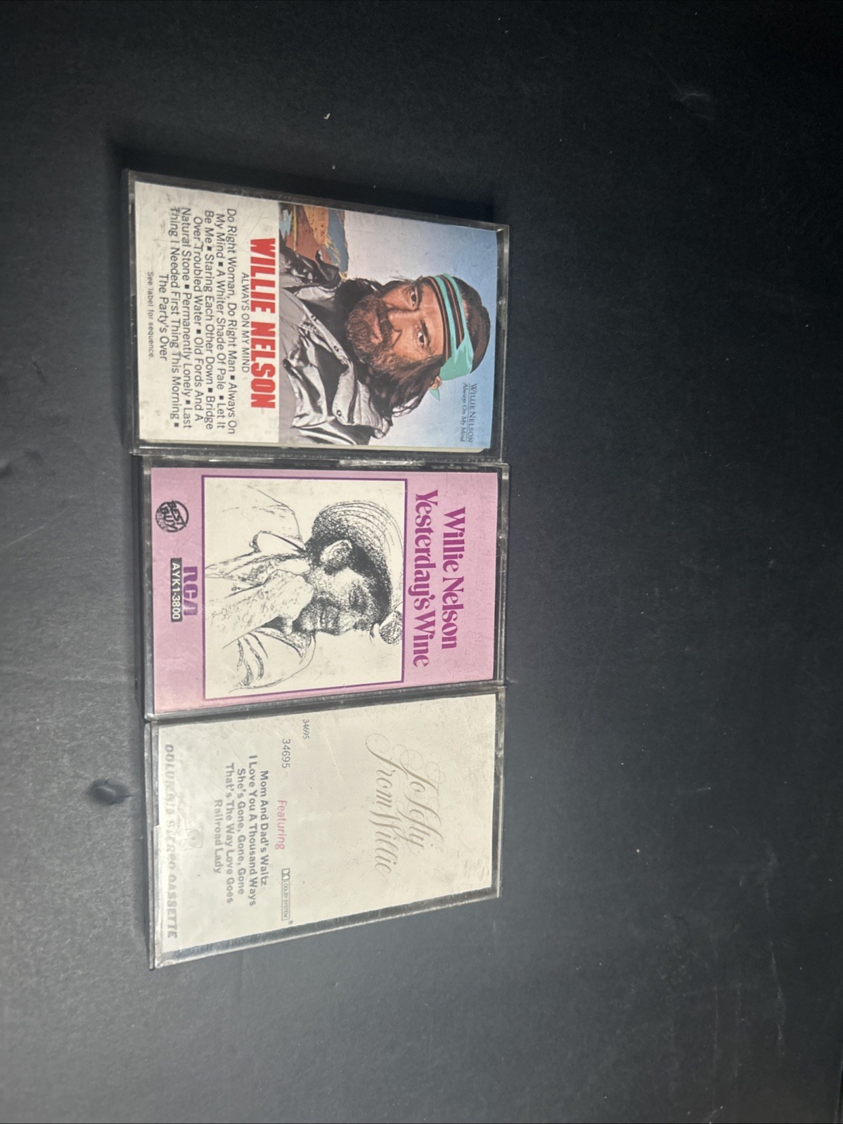Collection of three vintage Willie Nelson audio cassette tapes.