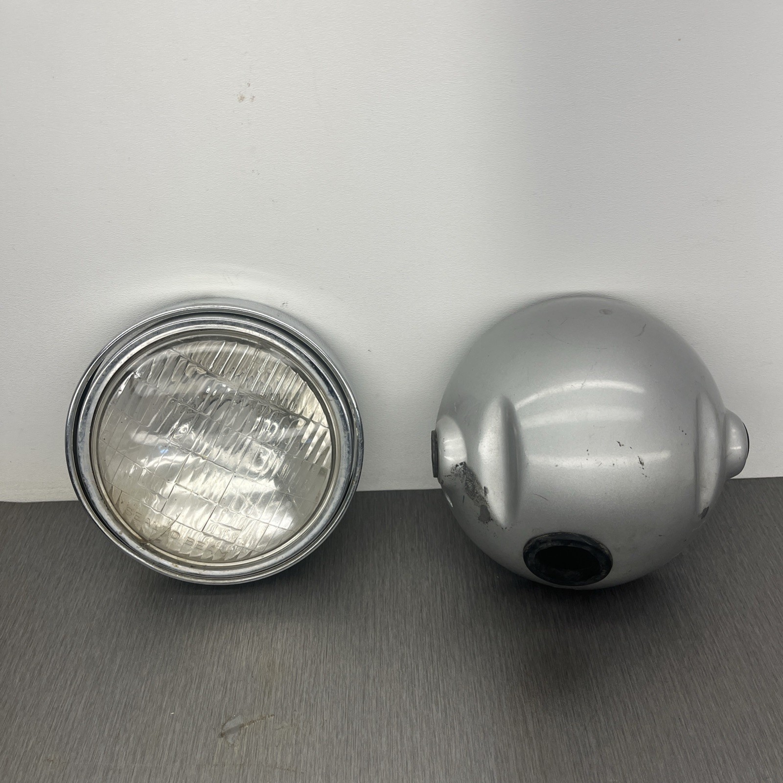 OEM 1974 - 1976 YAMAHA DT175 HEADLIGHT BUCKET and RIM OEM 1974 - 1976 YAMAHA DT175 HEADLIGHT BUCKET and RIM
