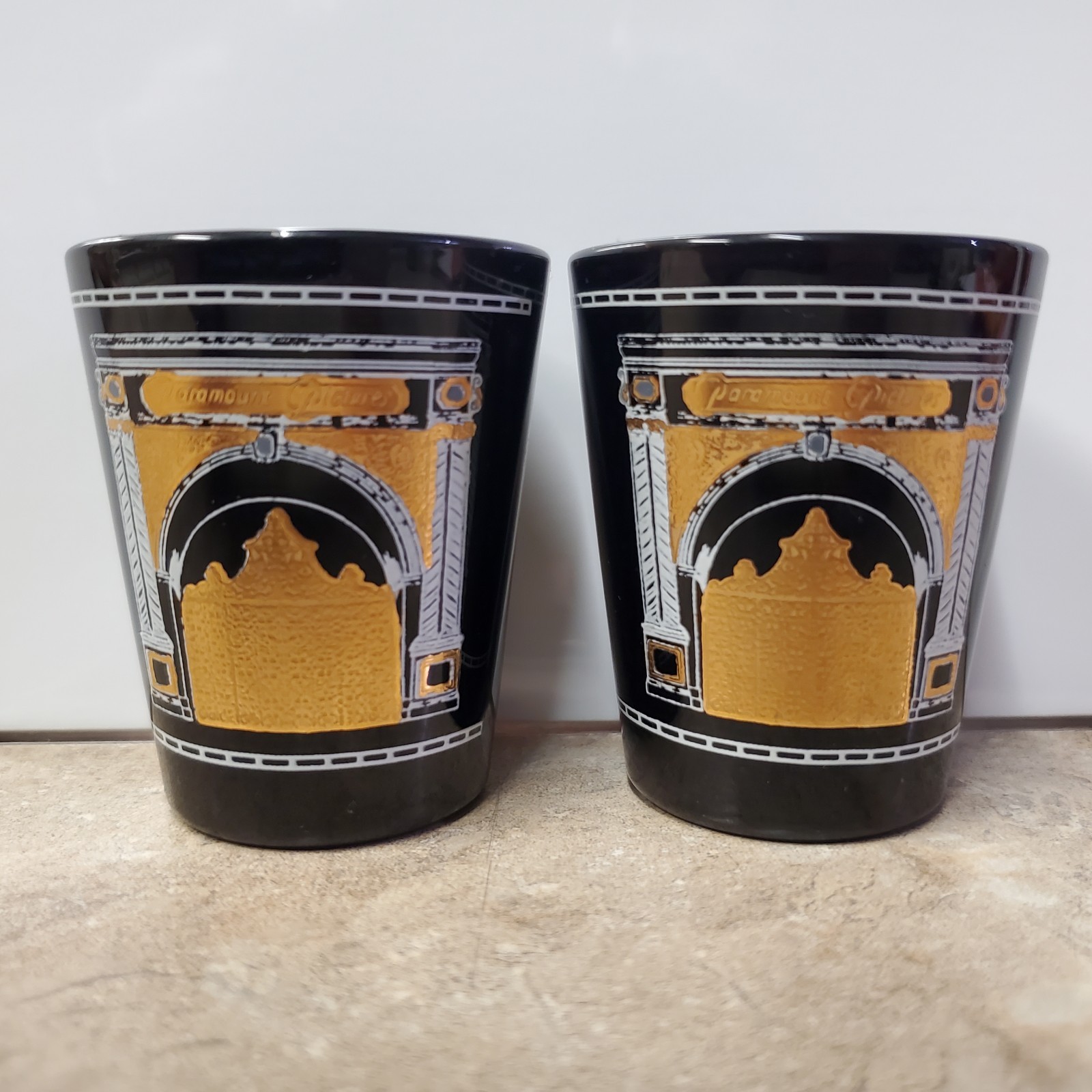 Paramount Pictures Gate Logo Shot Glasses. (2-PACK) 1995. Black and Gold. Rare Paramount Pictures Gate Logo Shot Glasses. (2-PACK) 1995. Black and Gold. Rare