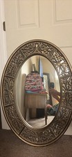 Antique pewter oval mirror is manufactured by The Uttermost Company. It has a de picture