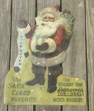 1910 “THE SANTA CLAUS FAVORITE” INTERWOVEN STOCKINGS DIECUT CARDBOARD EASEL SIGN picture